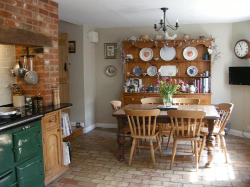 a kitchen with a table and chairs in a room at Motts Bed & Breakfast in Great Dunmow