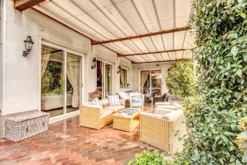 an outdoor patio with wicker chairs and a table at La Gaura Guest House in Casal Palocco