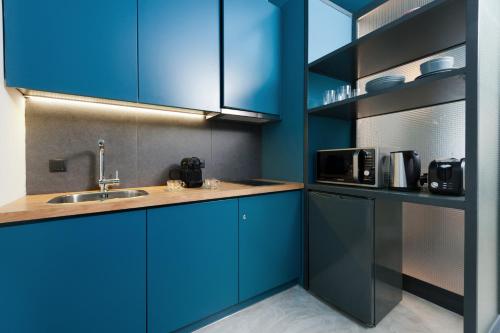 kuchnia z niebieskimi szafkami i zlewem w obiekcie Syntagma Square Modern Apartments w Atenach