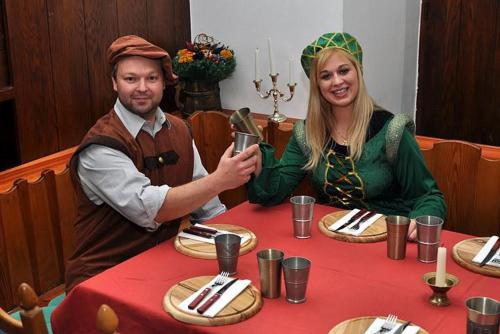 a man and woman sitting at a table in costumes at Hotel Zum Goldenen Hirschen in Freistadt