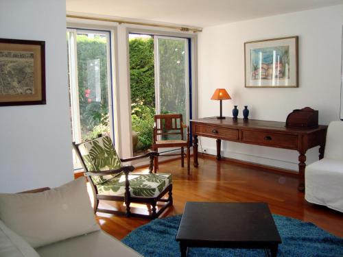 sala de estar con sofá, mesa y ventanas en Casa do Jasmim, en Sintra