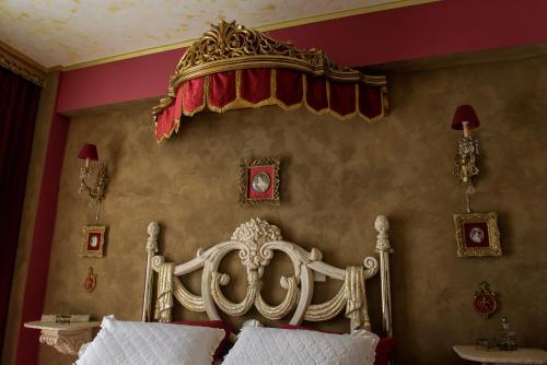 een slaapkamer met een wit bed met een kroon op de muur bij Katerina's Studios in Kardhamili