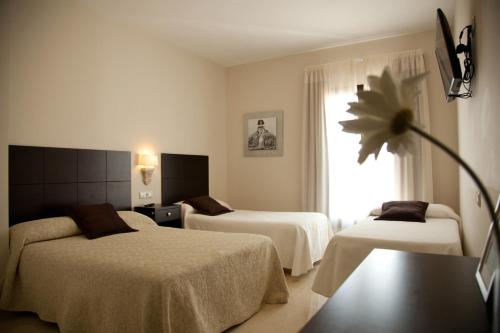 En eller flere senge i et værelse på Hotel El Capricho