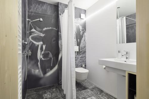 a bathroom with a cow on the shower door at Medelina in Curaglia