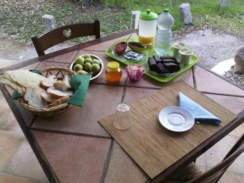 a picnic table with a basket of fruit and juice at Agriturismo Silitta in Siniscola