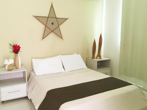 sypialnia z łóżkiem z gwiazdą na ścianie w obiekcie Green Paradise Residence w mieście Canoa Quebrada