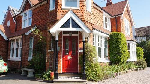 a red brick house with a red door at The Lawn Guest House Gatwick in Horley