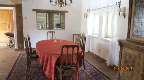 ein Esszimmer mit einem roten Tisch und Stühlen in der Unterkunft Meisenhof in Schalkenbach