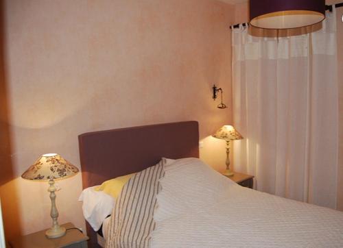 sypialnia z łóżkiem z dwoma lampami na stołach w obiekcie Le Clos Saint Paul w mieście Figeac