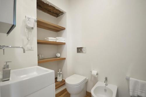 a white bathroom with a toilet and a sink at Villa Battista in Ercolano