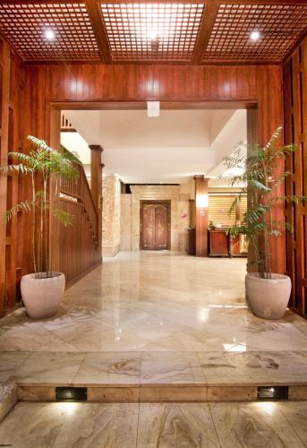 a lobby with two potted plants in a building at Best Western Kuta Villa in Kuta