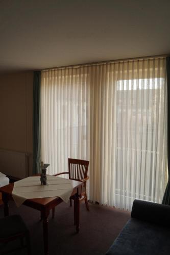 a living room with a table and a large window at Butjadinger Hof in Burhave