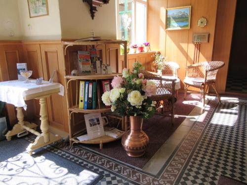 una sala de estar con un jarrón de flores y un fregadero en Waldpension Mück, en Gars am Kamp