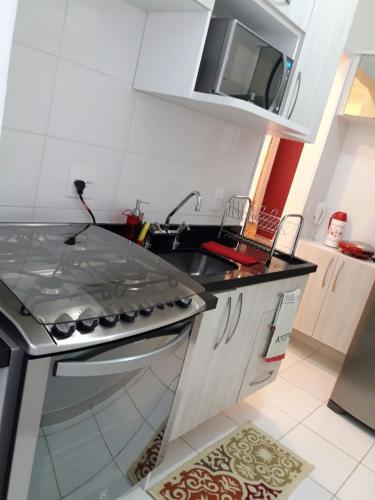 a kitchen with a sink and a stove at Apartamento Completo em Cotia - SP in Cotia