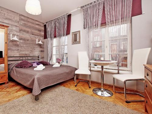 a bedroom with a bed and a table and chairs at Apartament Kameralny na Starówce in Gdańsk