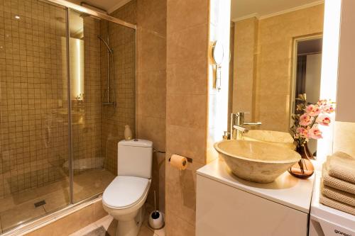 a bathroom with a toilet and a sink and a shower at Qult - Old City Pearl in Bucharest