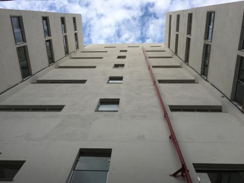 a tall white building with a red hose hanging from it at Pousada Soares in Aparecida
