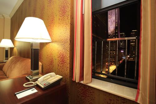 a room with a lamp and a phone and a window at Radio City Apartments in New York