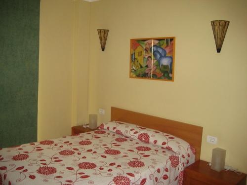 サンタクルス・デ・テネリフェにあるApartament in S/C Tenerife Center for 4 personsのベッドルーム1室(ベッド1台、赤と白の掛け布団付)