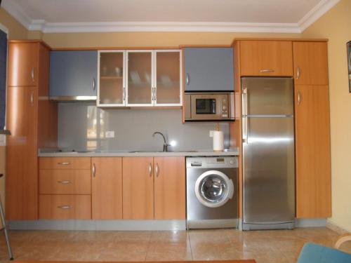 cocina con armarios de madera y nevera de acero inoxidable en Dúplex céntrico en S/C, en Santa Cruz de Tenerife