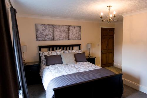 a bedroom with a large bed and a chandelier at Belford House Self Check-in Rooms & Apartments in Haltwhistle