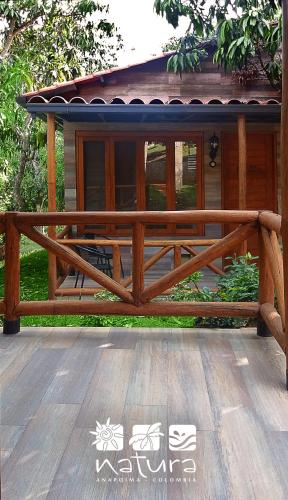 a wooden bench in front of a house at Natura Reservado - Hoteles Natura in Anapoima