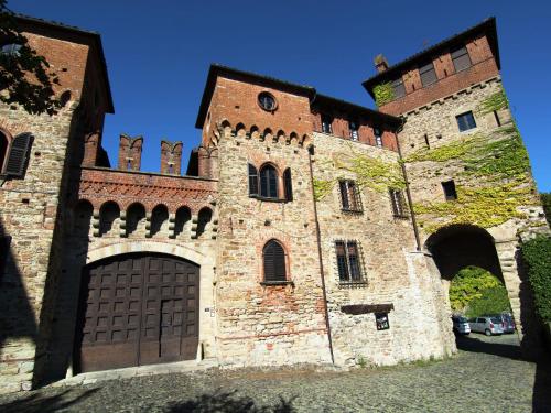 un gran edificio de ladrillo con una gran puerta de madera en Belvilla by OYO Nobile, en Tagliolo Monferrato