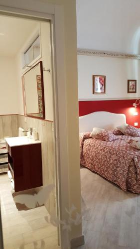 a bedroom with a bed and a sink and a mirror at Five Roses Bed & Breakfast in Pisa