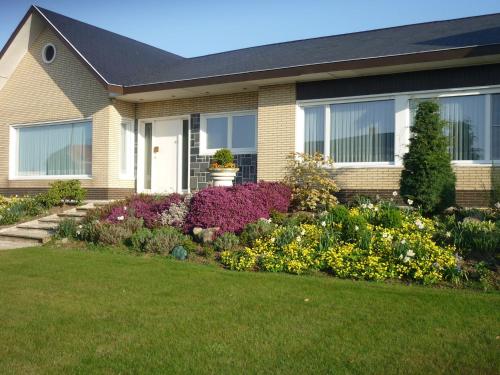 a house with a garden of flowers in front of it at Spacious holiday home in Ruiselede with a garden in Ruiselede