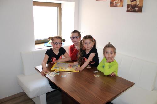 a man and three children sitting at a table at Post Hostel For Youth, Students and Pilgrims in Lavamünd