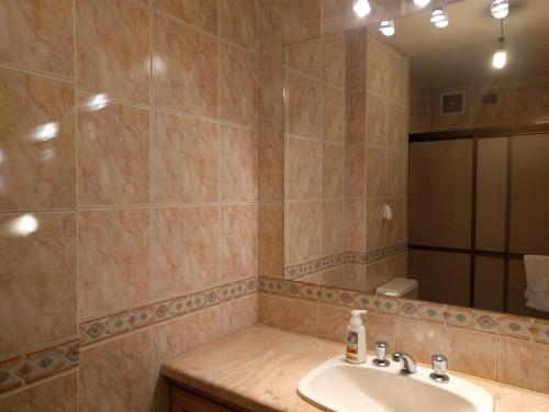 y baño con lavabo y espejo. en Apartamentos Sercan, en Cochabamba