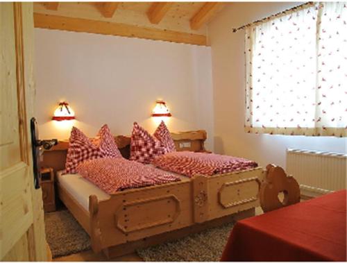 1 dormitorio con 2 camas y almohadas rojas en Apartment Großvenedigerblick en Neukirchen am Großvenediger