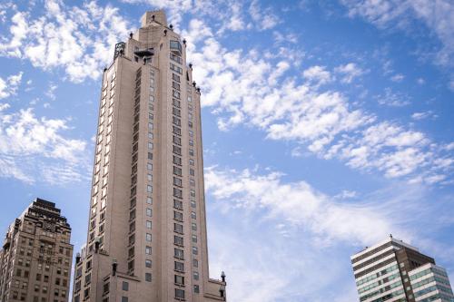 a tall building with a blue sky and clouds at Four Seasons Hotel New York in New York