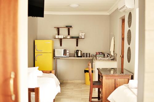 a small kitchen with a yellow refrigerator and a table at Stel26 in Bloemfontein