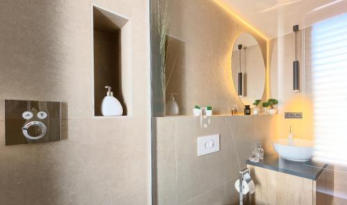 a bathroom with a shower and a sink and a mirror at Apartment Mondo Deluxe in Kaštela