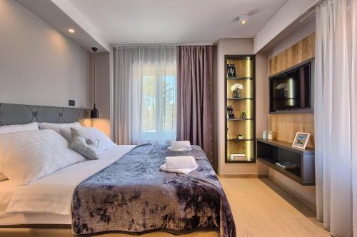 a bedroom with a large bed and a television at Apartment Mondo Deluxe in Kaštela