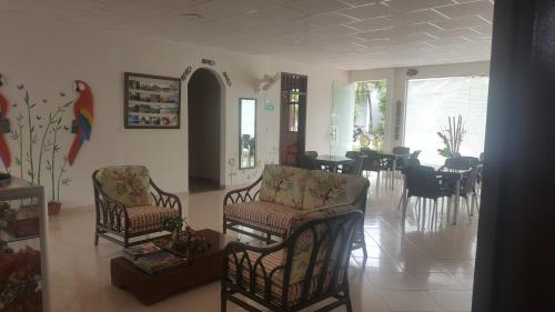 a living room with two chairs and a dining room at Hotel Orinoco Real in Inírida