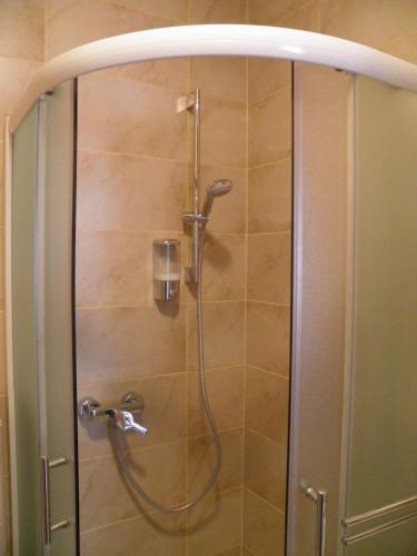 a shower with a hose in a bathroom at Apartman Radošić in Hvar