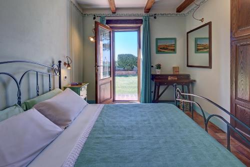 a bedroom with a bed and an open door at Podere Fontegallo in Castiglione del Lago