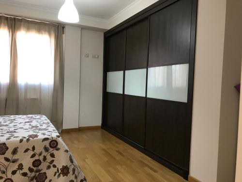 a bedroom with a large black cabinet and a bed at High Rentxacobeo in Sarria