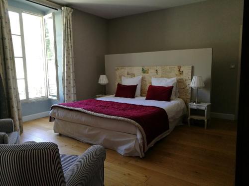 a bedroom with a large bed with red pillows at L'Observance Bed & Breakfast in Avignon
