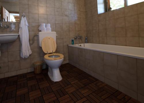 a bathroom with a toilet and a tub and a sink at Q.pova house in Kovachevitsa