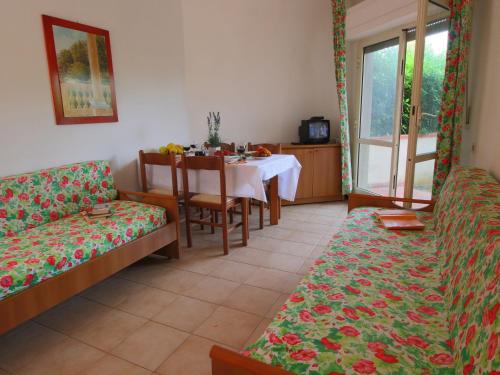 Santa LiberataにあるScenic Holiday Home in Giannella near Beachのリビングルーム(テーブル、ソファ付)