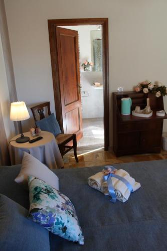 a room with a bed and a table and a door at Affittacamere Casa Mac & Rose in San Quirico dʼOrcia