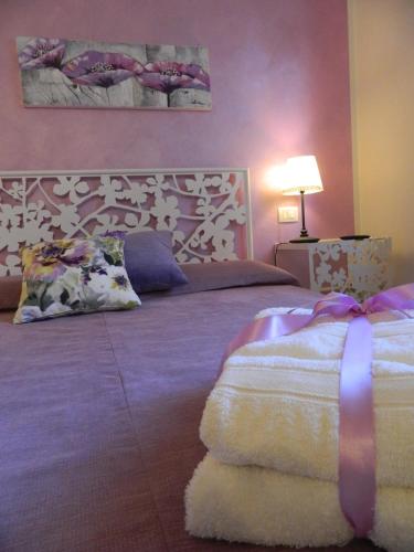 a bedroom with a large bed with a purple wall at Affittacamere Casa Mac & Rose in San Quirico dʼOrcia