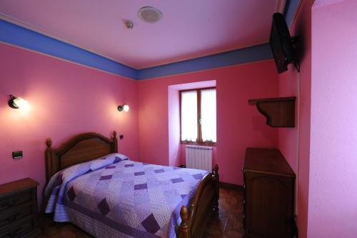 a bedroom with pink and blue walls and a bed at Hotel Rural Bereau in Lesaka