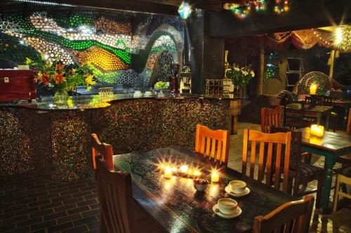 a restaurant with a table and chairs and lights at Rabbit Hole Hotel in Krugersdorp