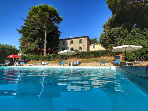 - une piscine avec des chaises longues et des parasols dans l'établissement Belvilla by OYO Glicine, à Gualdo Cattaneo