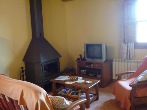 a living room with a fireplace and a tv at Mansion in Maians with Private Pool in Castellfullit del Boix