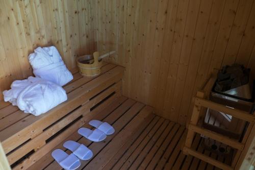 una sauna in legno con asciugamani bianchi su un pavimento in legno di Hotel Villamare a Fontane Bianche